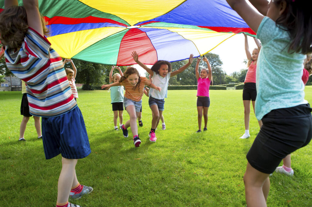 Children running under a colorful tarp | Summer Dental Health | Omaha Dentistry